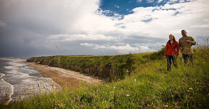 man and woman walking along the cliff top at Blast Beach, Durham Heritage Coast.